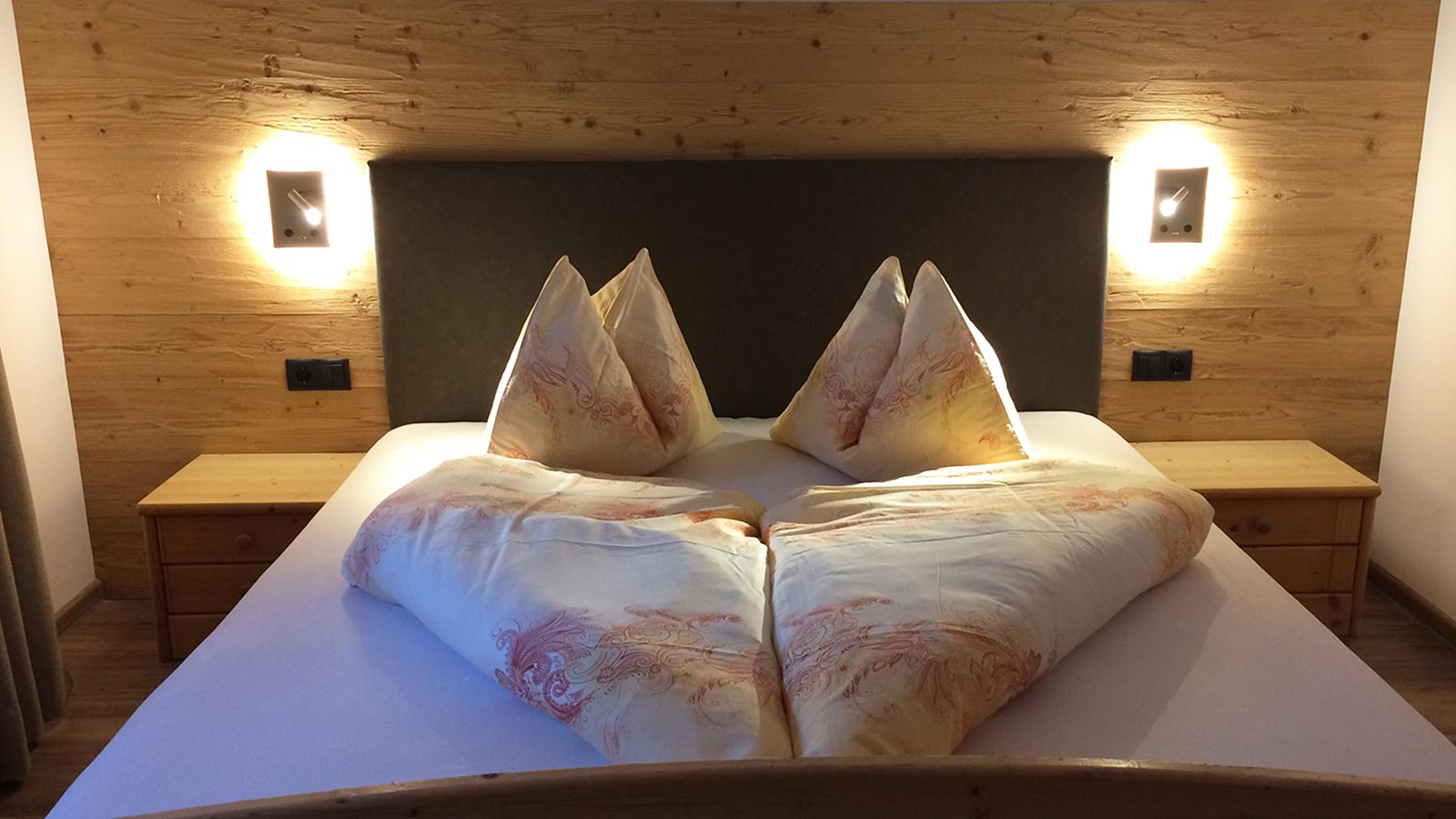 Il letto illuminato e preparato per gli ospiti presso l'Albergo Blosegg